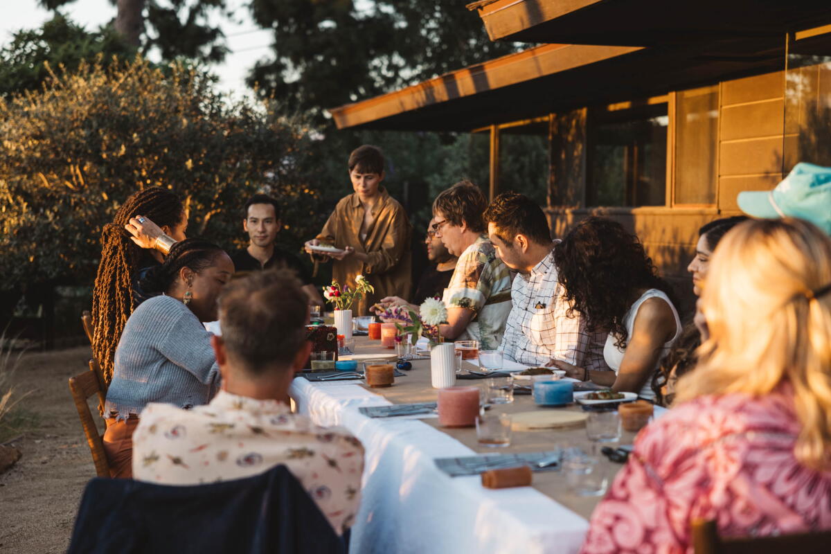 Readers gathered around one long table in warm evening light